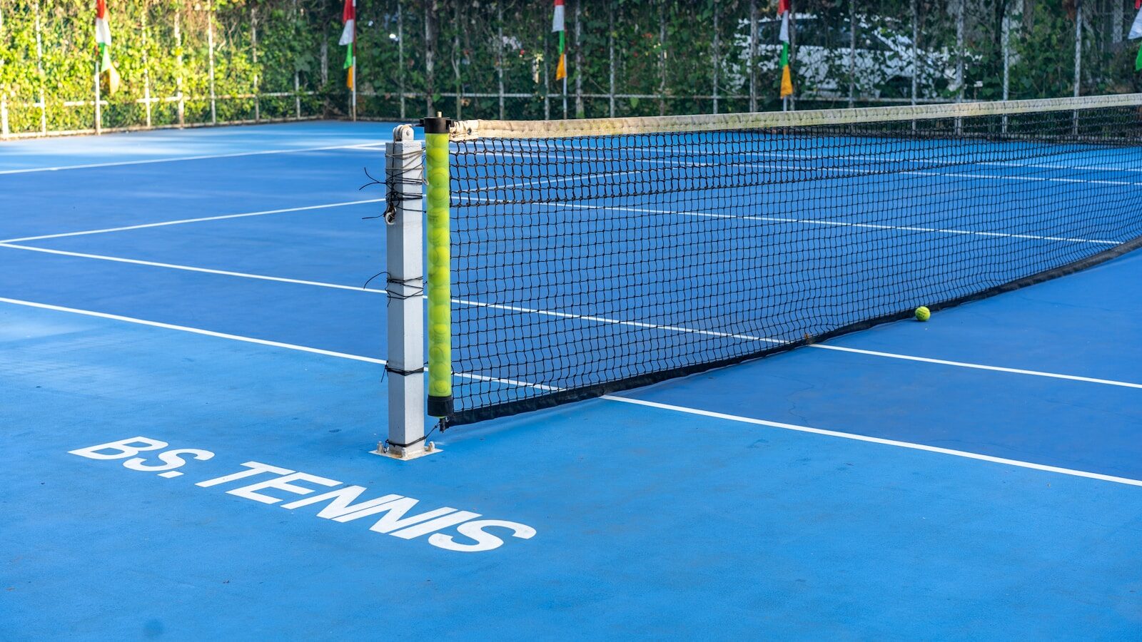 Blue tennis court with net and ball