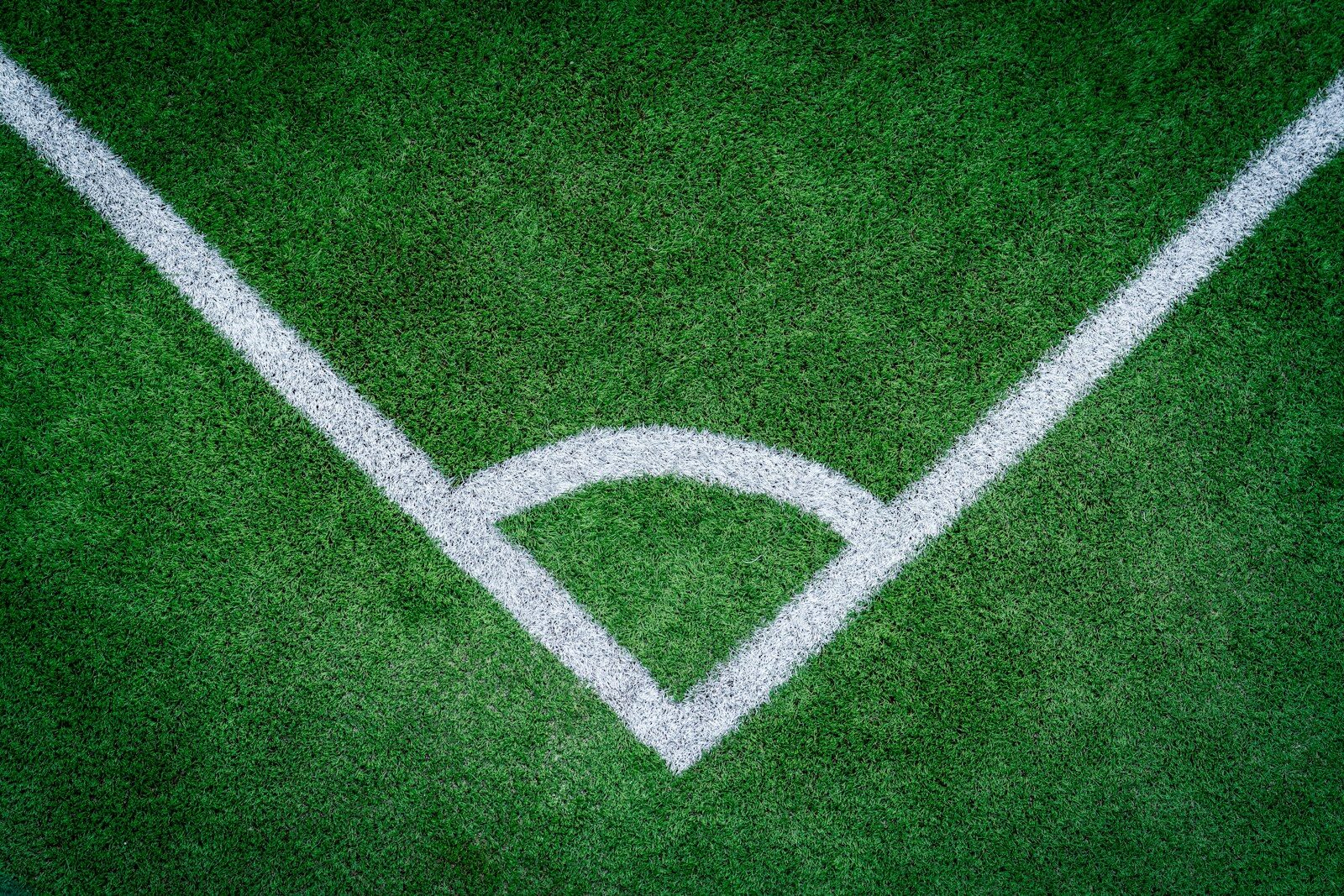 Corner of a green soccer field with white lines